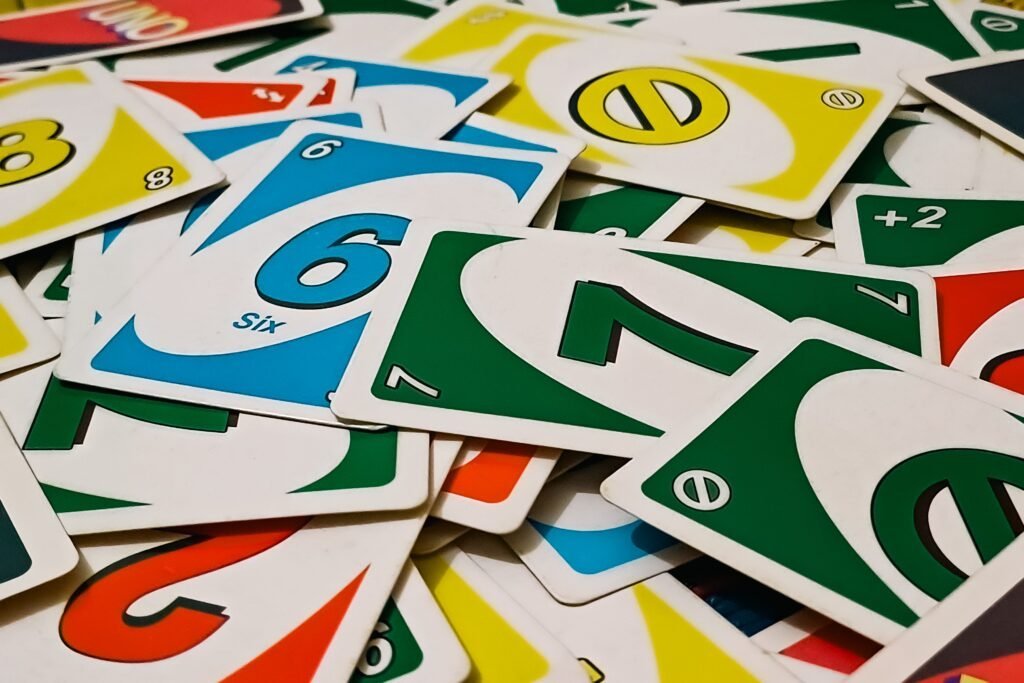 A vibrant display of Uno cards scattered in a random pile, showcasing various numbers and colors.